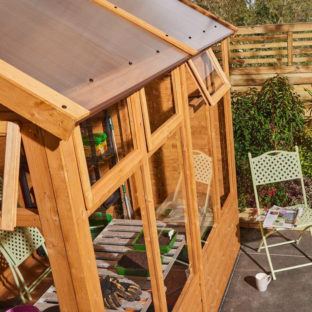 8x6 growhouse with open window, chair, and garden view